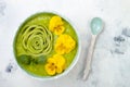 Breakfast detox green smoothie bowl topped with kiwi rose and edible Pansy flowers. Royalty Free Stock Photo