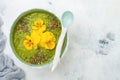 Breakfast detox green smoothie bowl topped with superfoods, chia seeds, bee pollen and edible flowers. Overhead, flat lay Royalty Free Stock Photo