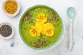 Breakfast detox green smoothie bowl topped with superfoods, chia seeds, bee pollen and edible flowers. Overhead, flat lay Royalty Free Stock Photo