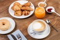 Breakfast with donut and croissants and orange juice on a wooden table Royalty Free Stock Photo