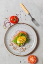 Poached egg sandwich with hollandaise sauce, tomatoes and onions on a gray plate. eggs Benedict. Overhead,vertical, with