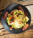 Breakfast egg omelette with sausage, spinach and bread on plate set on wooden table