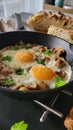 Breakfast with eggs end mushrooms in a ironcast pan