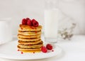 Plate with delicious pancakes with raspberries and honey on white background.