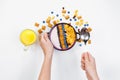 Breakfast, female hands holding a spoon over a bowl with homemade yogurt and cornflakes, and fresh blueberries, a glass of orange