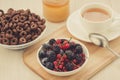 breakfast with flakes, berries, honey and a cup of tea/breakfast with flakes, berries, honey and a cup of tea. selective focus Royalty Free Stock Photo