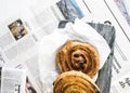 Breakfast flatlay with breadrolls and newspaper.