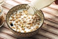 Breakfast food background. Milk Pouring Over Granola on light table napkin, Healthy vegetarian breakfast. Diet Nutrition Concept