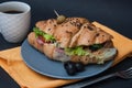 Breakfast Food with Coffee. Croissant Sandwich with Fried Eggs and Fresh Vegetables on Gray Plate with Orange Napkin over Dark Gra Royalty Free Stock Photo