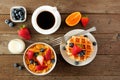 Breakfast food table scene. Fruits, cereal, waffles, milk and coffee. Top view over wood. Royalty Free Stock Photo