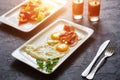 Breakfast from fried egg, bacon, vegetable salad and carrot juice. On a dark stone background Royalty Free Stock Photo