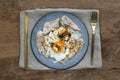 Breakfast with Fried egg, Roasted pork sprinkle garlic, chili in plate with Knife and fork on old wooden table Royalty Free Stock Photo