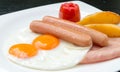 Breakfast with fried egg, sausages, tomato, potatoes fried on white plate Royalty Free Stock Photo