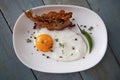 Breakfast. Fried eggs and bacon on an oval plate.