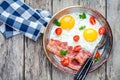 Breakfast with fried eggs, bacon, tomatoes and parsley Royalty Free Stock Photo