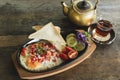 Breakfast with fried eggs in cast iron frying pan  with bread and vegetables on old dark wooden table background,spot focus,top Royalty Free Stock Photo