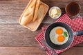 Breakfast with fried eggs on pan and bread with butter, hot coffee on table, Healthy homemade meal. Top view and Copy space. Royalty Free Stock Photo