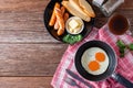 Breakfast with fried eggs on pan and sausage grill with toast, c Royalty Free Stock Photo