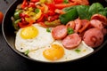 Breakfast. Fried eggs with sausage and vegetables in a frying pan Royalty Free Stock Photo