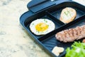 Breakfast, fried steak or cutlet, salad with tomato and green vegetables, toast, potato, egg close-up, light background Royalty Free Stock Photo