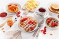 Breakfast with granola berry nuts, waffle, toast, jam, chocolate spread and tea Royalty Free Stock Photo