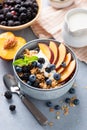 Breakfast granola bowl with yogurt, peach and berries