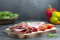 Breakfast with ham slices isolated on cutting board with fresh vegetables over dark background Royalty Free Stock Photo
