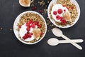 Breakfast homemade baked granola, red garden organic currants, figs and mint portions. Top view.