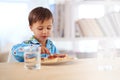 Breakfast is important for a growing boy. A cute little boy eating breakfast.