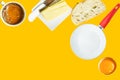 Breakfast ingredients freshly brewed coffee butter slice of bread cracked raw egg frying pan on yellow background