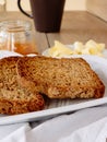 Breakfast with integral toast, butter and apricot jam on wooden table Royalty Free Stock Photo