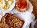 Breakfast with integral toast, butter and apricot jam on wooden table Royalty Free Stock Photo