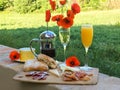 Breakfast with Jamon, juice, coffee, cheese, bread and poppy flowers