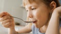 Breakfast in the Kitchen: Portrait of Adorable Little Girl Eating Healthy Granola Cereal with Milk Royalty Free Stock Photo