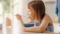 Breakfast in the Kitchen: Portrait of Adorable Little Girl Eating Healthy Granola Cereal with Milk Royalty Free Stock Photo