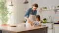 Breakfast in the Kitchen: Young Beautiful Mother Pours Cereal into Bowl, Adorable Little Daughter Royalty Free Stock Photo