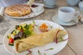 Breakfast, light meal table setting with crepe wrap, salad and Belgian waffles Royalty Free Stock Photo