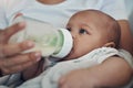 Breakfast, lunch and dinner all in a bottle. an adorable baby girl being bottle fed by her mother on the sofa at home. Royalty Free Stock Photo