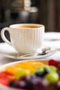 Breakfast and luxury, cup of coffee with milk and fruit platter on the served table for hospitality and gastronomy Royalty Free Stock Photo