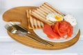 Breakfast menu: toasted bread, smoked salmon, poached eggs and cup of coffee on white windowsill Royalty Free Stock Photo