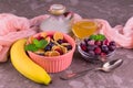 Breakfast mini pancakes with honey banana and berries on a gray background.