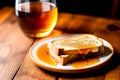 Slice of bread with honey on a white plate on wooden table