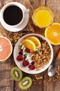 Breakfast with muesli, fruit, coffee cup and orange