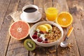 Breakfast with muesli, fruit, coffee cup and orange