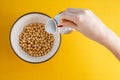 Healthy breakfast. A young woman is pouring cereals with milk Royalty Free Stock Photo