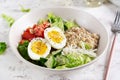 Breakfast oatmeal porridge with boiled eggs, tomato, cucumber and onions.