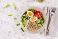 Breakfast oatmeal porridge with boiled eggs, tomato, cucumber and onions.