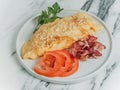 Breakfast omelet of eggs on a white marble background.