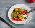 Breakfast with omelet and tomatoes sprinkled with herbs on a round white plate with a fork Royalty Free Stock Photo