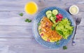 Breakfast. Omelette with radish, red onion and fresh salad on blue plate.